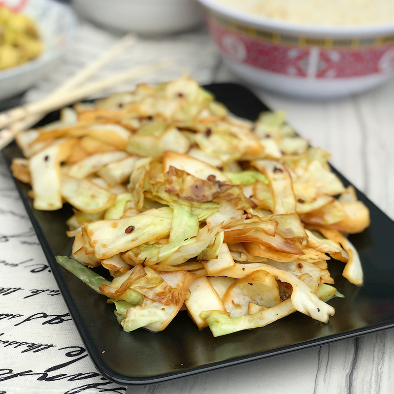 A closeup of the spicy steamed cabbage, displayed on a rectangular black dish.